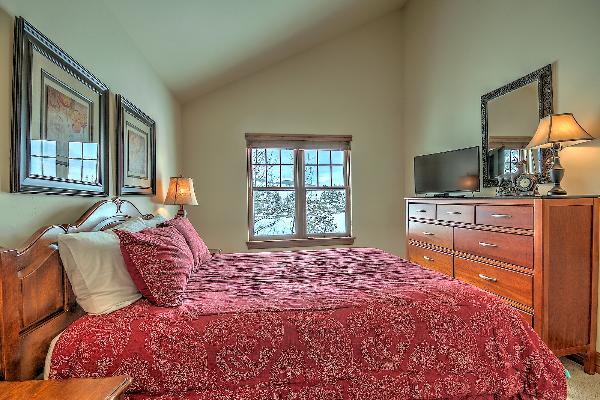 Master bedroom with flatscreen TV and double sink bathroom