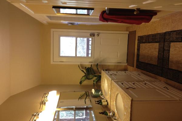 Bathroom with his & her sinks, shower with double shower head and entrance to covered private deck. 