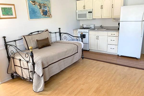 Kitchen with microwave, refrigerator, oven & stove in back.