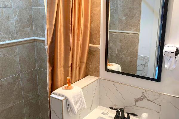 Updated shower with beautiful tile in bathroom.