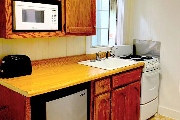 Kitchen with microwave, refrigerator, oven, & stove.