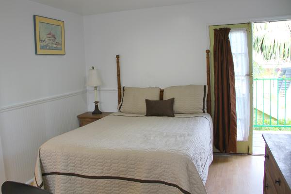 Queen bed (sleeps 2) & balcony with partial ocean view.