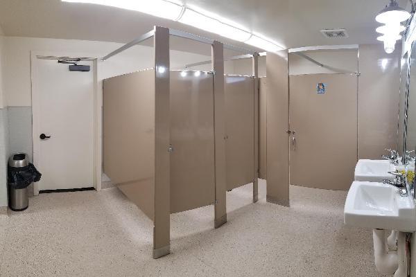 ADA compliant restrooms with changing tables. The women's restroom also has small changing area with mirrors and a bench.