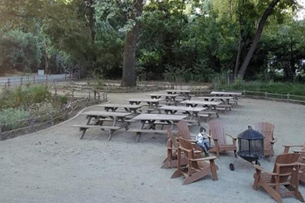 The courtyard features 10 picnic tables and 6 adirondack chairs on decomposed granite, surrounded by a native plant garden and mature trees.